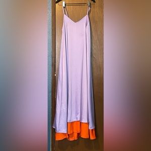 Lilac poly-satin gown with orange peekaboo lining.